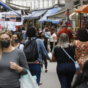 Foto de pessoas andando na rua e olhando produtos