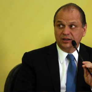 Foto do deputado federal Ricardo Barros falando em um microfone à frente de um fundo de cor amarela