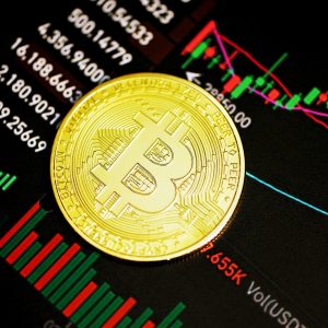 Foto de Bitcoin com cotações do mercado de ações ao fundo