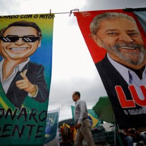 Eleições 2022, Pedestre passa por materiais de campanha presidencial que retratam o ex-presidente do Brasil Luiz Inácio Lula da Silva e o presidente Jair Bolsonaro
