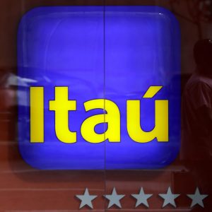 Foto do logo do Itaú em uma agência bancária da empresa
