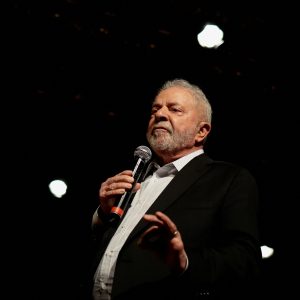 Imagem do presidente eleito Luiz Inácio Lula da Silva segurando um microfone e falando em público