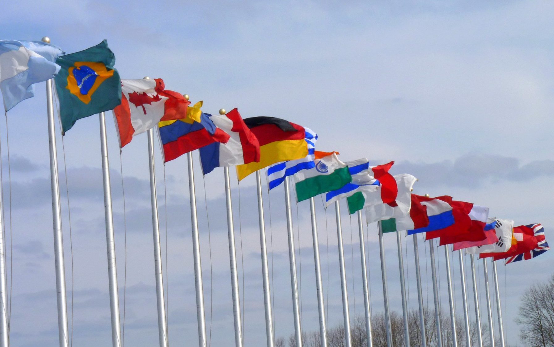 Foto de bandeiras de países tremulando contra o vento