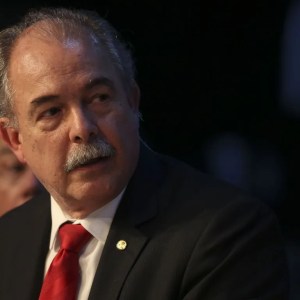 Foto de Aloizio Mercadante, presidente do BNDES. Ele é homem, tem um bigode branco, veste um terno preto e gravata vermelha.