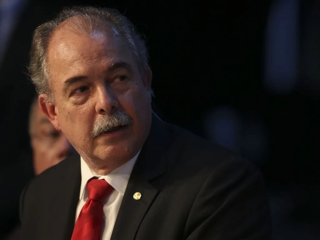 Foto de Aloizio Mercadante, presidente do BNDES. Ele é homem, tem um bigode branco, veste um terno preto e gravata vermelha.