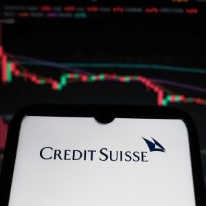 Foto de um celular com o logo do banco Credit Suisse, que vendeu sua operação de fundos imobiliários para o Pátria Investimentos
