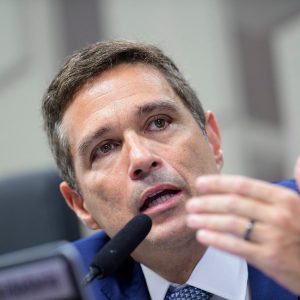 Foto de Roberto Campos Neto, presidente do Banco Central, falando ao microfone durante audiência no Senado. Ele é homem, usa terno azul-marinho, camisa branca.