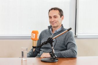 Foto de Marcelo Tangioni, CEO da Mastercard, sentado e sorrindo com um microfono da Inteligência Financeira a sua frente.