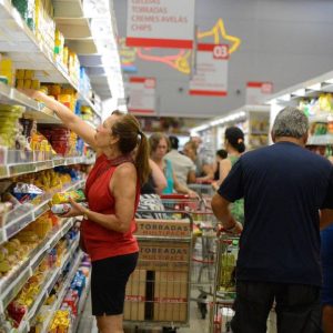 Foto de uma mulher fazendo compras em um supermercado. A matéria explica os principais dados do IPCA de março de 2024.