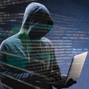 Homem com capuz escondendo o rosto segura um notebook para cometer golpes pela internet, hacker