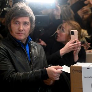 Foto de Javier Milei, candidato à presidência da Argentina, depositando o voto em cédula de papel em uma urna.