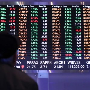 Foto de homem olhando painel da B3. A matéria descreve o pregão da bolsa de valores hoje (17/10)