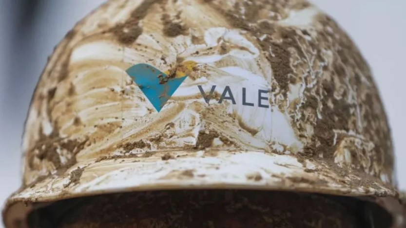 Foto de um capacete branco da mineradora Vale (VALE3) usado por funcionários. Ele está sujo de lama e contém o logo da empresa.