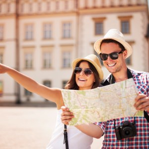 Imagem de um homem e uma mulher olhando um mapa em alguma viagem para a matéria sobre viagem de fim de ano barata.