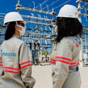 Foto de duas técnicas de frente para uma usina elétrica, com uma jaqueta da Energisa, que tem agenda para pagar dividendos em janeiro de 2024.