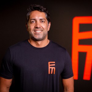 Foto de Alexandre Guerrero, CEO da Eletromidia (ELMD3). Ele é homem, branco e usa uma camisa preto com logo laranja da Eletromidia.