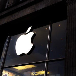 Foto de uma parede de vidro, com o símbolo de uma maçã, logotipo da empresa Apple.