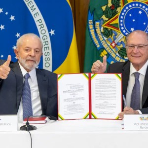 Foto de Luiz Inácio Lula da Silva, presidente do Brasil, e Geraldo Alckmin, vice-presidente. Eles mostram a assinatura do decreto de debêntures de infraestrutura