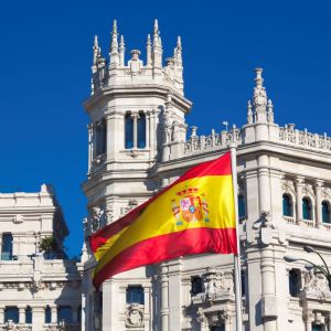 Imagem para a matéria sobre estudar na Espanha em que aparece a bandeira da Espanha e ao fundo o Palacio de Cibeles
