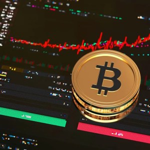 Imagem para a matéria sobre investimento em bitcoin em que aparece uma moeda dourada com o símbolo do bitcoin dentro. Ao fundo alguns gráficos.