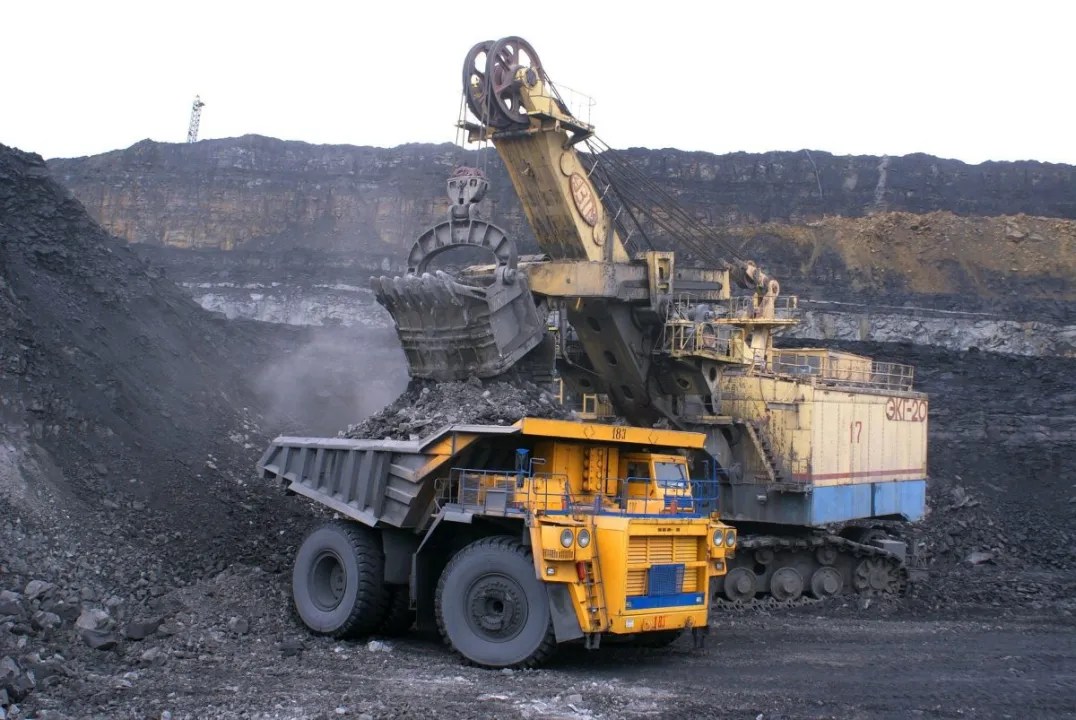 Foto de uma escavadeira sendo preenchida com carvão e minério. A matéria lista as ações em alta no Ibovespa em 17/04/2024