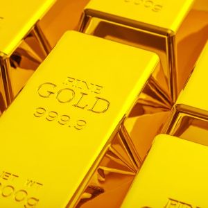Imagem para matéria sobre investimento em ouro em que aparecem várias barras de ouro.