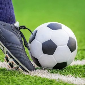 Foto para a matéria sobre a economia do futebol em 2023 em que aparece um pé de jogador com chuteira chutando uma bola.