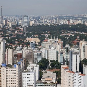 Foto de vista aérea de cidade com prédios residenciais e árvores no horizonte. A matéria lista fundos imobiliários baratos pelo valor da cota no mercado.